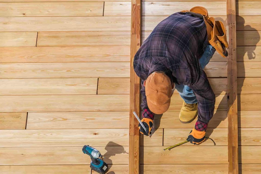man building a backyard deck with tools